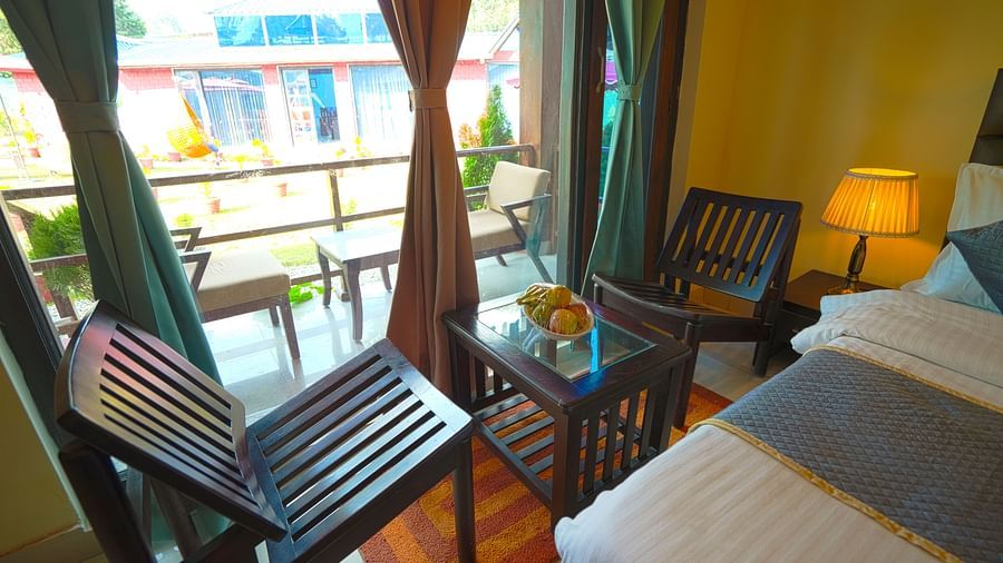 Two chairs facing each other, on the either side of a coffee table, near a bed